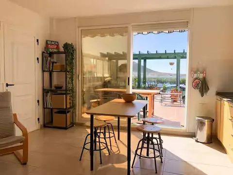 Esstisch neben der Schiebetür mit Blick auf die Terrasse und das Meer.