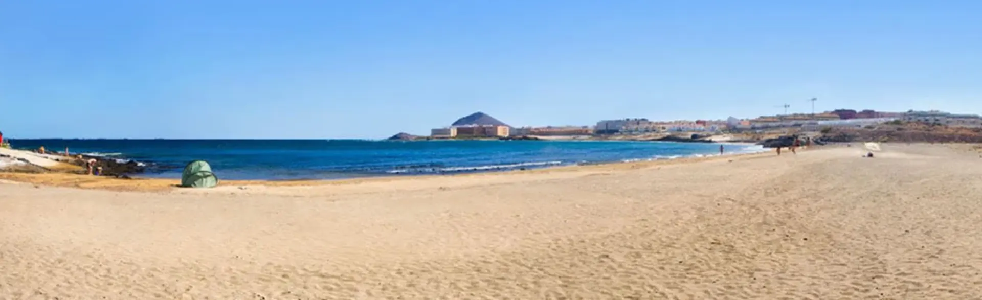 Strand von La Jaquita und El Salado, mit Montaña Roja und dem Ort El Médano im Hintergrund.