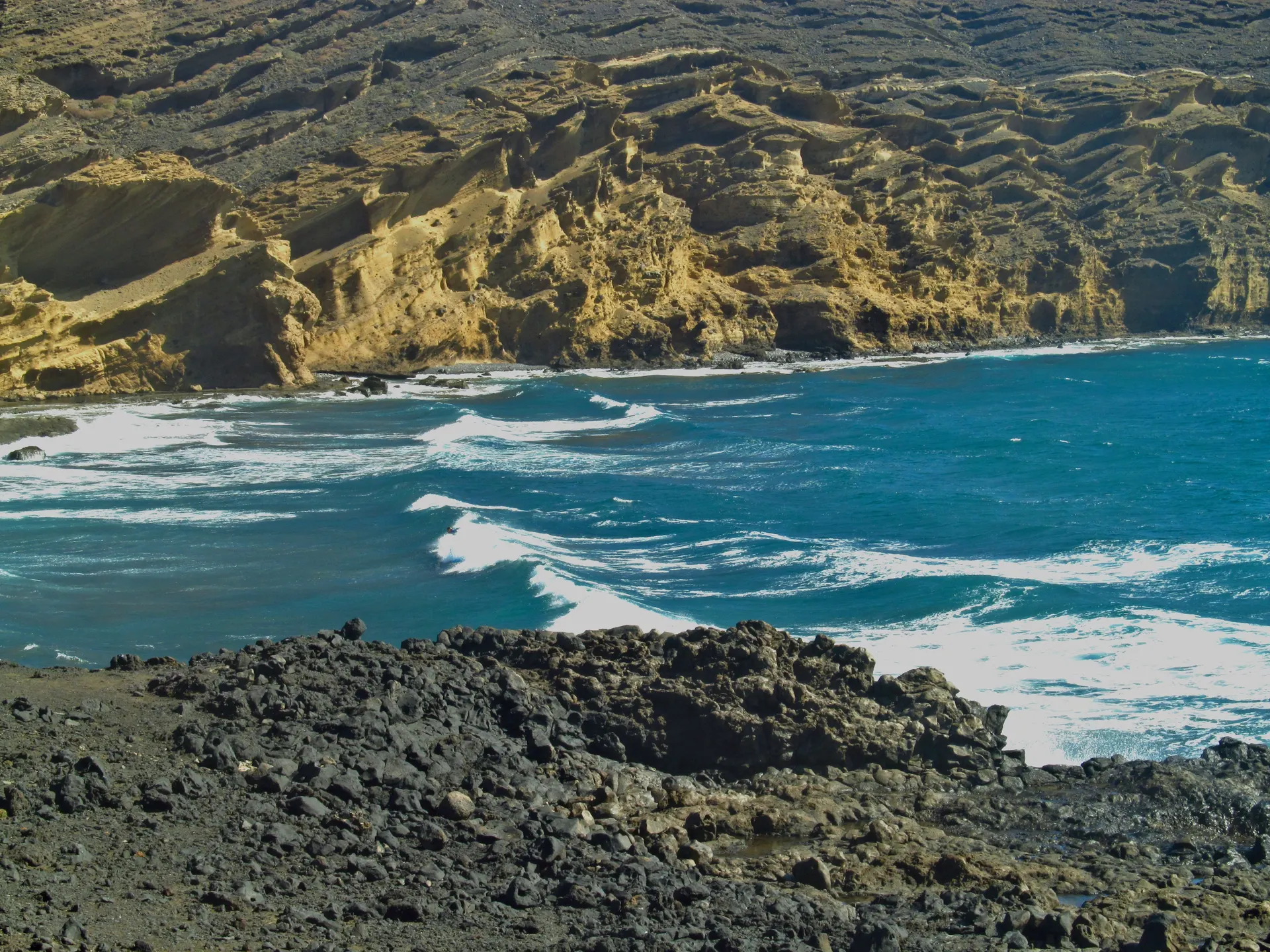 Vulkanische Klippen und türkisfarbenes Wasser am Playa Pelada bei El Médano.