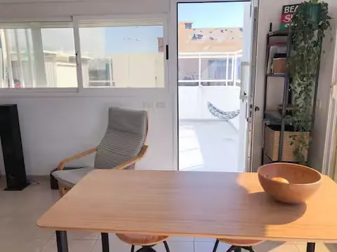 Tisch und Stühle auf der Terrasse, neben der Schiebetür.